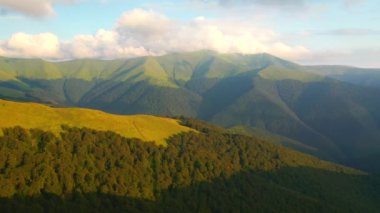 Güneş ışığında yeşil dağ sıraları, kuş bakışı. 4k, İHA videosu ile çekilmiştir..