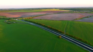 Kırsal yolda uçan İHA tarım arazilerinden ve tarlalardan geçiyor. UHD 4k insansız hava aracı videosunda çekildi.