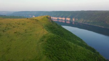 Büyük nehrin manzarası ve kuşbakışı yeşil vadi. Dniester River, Ukrayna, Avrupa. Sinematik drone çekimi. UHD 4k video 'da çekildi. Toprağın güzelliğini keşfedin.