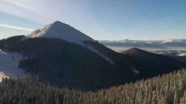 Mükemmel bir kış manzarası ve kuş bakışı karlı bir tepe. UHD 4k video ile çekildi.