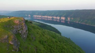 Güneşli bir günde muhteşem kayalık kanyon ve yeşil tepeler. UHD 4k video ile çekildi.