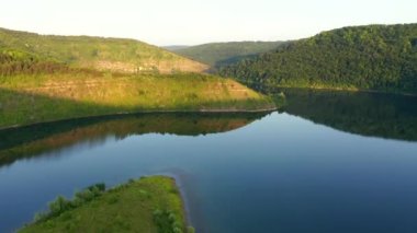Yeşil tepelerden akan kıvrımlı nehrin kuş bakışı manzarası. Dniester Nehri, Ukrayna, Avrupa. Sinematik drone çekimi. UHD 4k video 'da çekildi. Toprağın güzelliğini keşfedin.