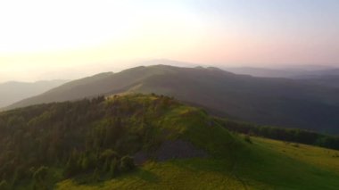 Bir dron dağlık dağlardaki yeşil çayırlar üzerinde uçuyor. UHD 4k video ile çekildi.