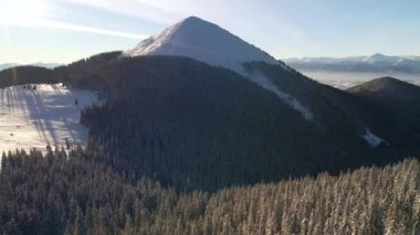 Mükemmel bir kış manzarası ve kuş bakışı karlı bir tepe. UHD 4k video ile çekildi.