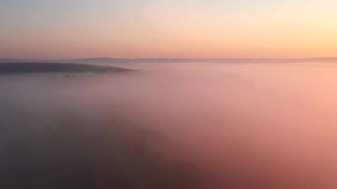Şafaktan önce ovayı kaplayan kalın bir sis üzerine bir dron atışı. UHD 4k video ile çekildi.