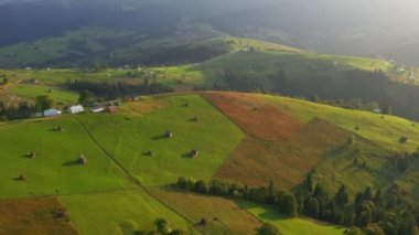 Sabahın köründe yeşil yuvarlanan tepelerin olduğu harika bir köy manzarası. UHD 4k video ile çekildi.