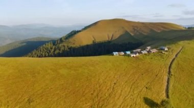 Yeşil tepelerdeki bir kuş bakışı dağ yerleşiminden. UHD 4k video ile çekildi.