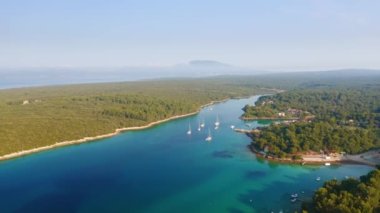 Güneşli bir günde Cres adasının mavi gölünün muhteşem manzarası. UHD 4k insansız hava aracı videosunda çekildi.