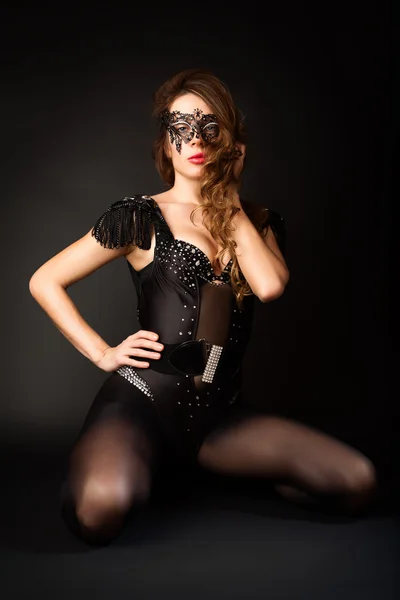 Красивая девушка в маскарадной маске на черном фоне . — стоковое фото