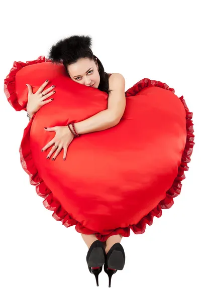 Een meisje met een hart in de vorm van kussens. — Stockfoto