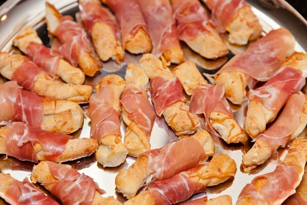 Breadsticks with prosciutto Stock Photo