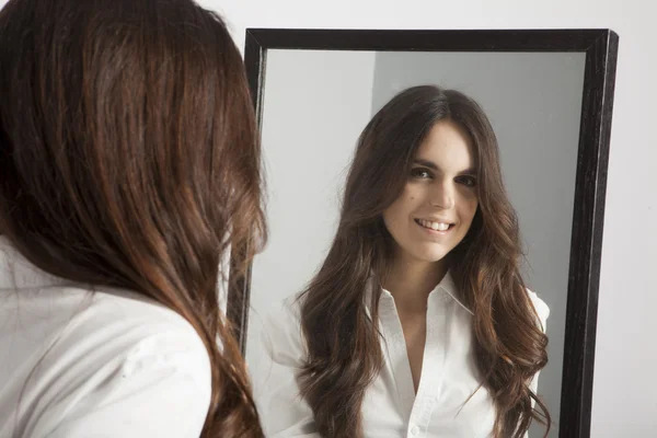 Mujer joven real mirando en un espejo —  Fotos de Stock