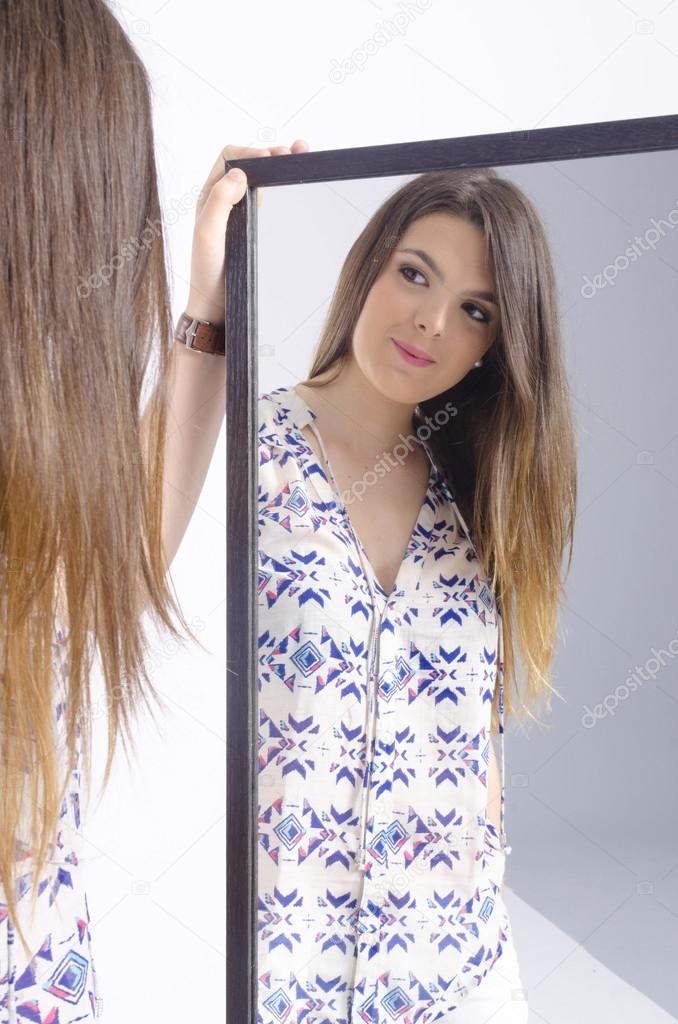 Real young woman looking in a mirror