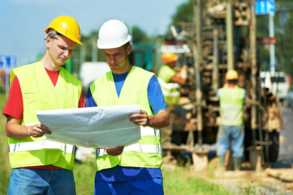 Инженеры-строители на стройплощадке дорожных работ
