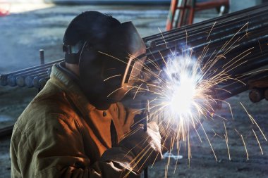 Worker welding with electric arc electrode clipart