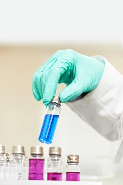 Hand in de handschoen met kolf test op apotheek lab — Stockfoto
