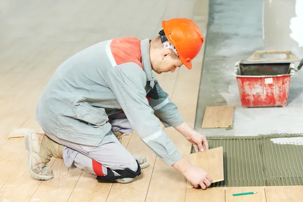 Fliesenleger bei industrieller Bodenfliesensanierung — Stockfoto