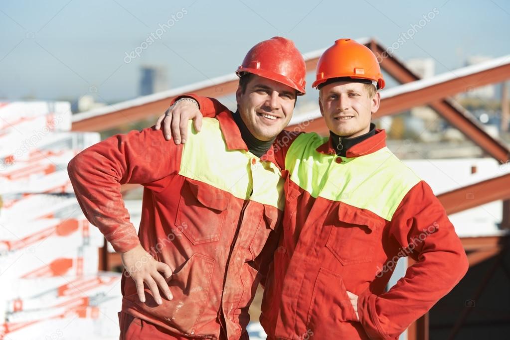 Happy builder workers at construction site