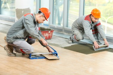 Two tilers at industrial floor tiling renovation clipart