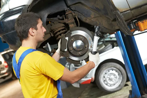 Auto mechanik w pracy naprawy zawieszenia samochodu — Zdjęcie stockowe