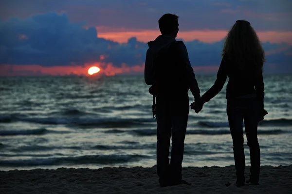 Young family couple at sunset beach — Stock Photo, Image