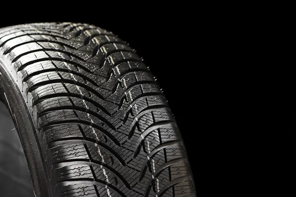 Zimní pneumatika na černém pozadí — Stock fotografie