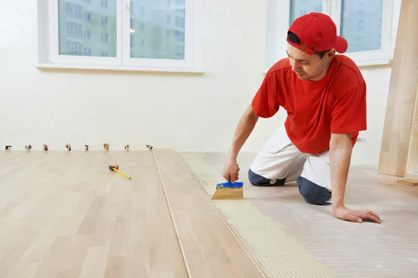 Trabajador de parquet agregando pegamento en el suelo —  Fotos de Stock