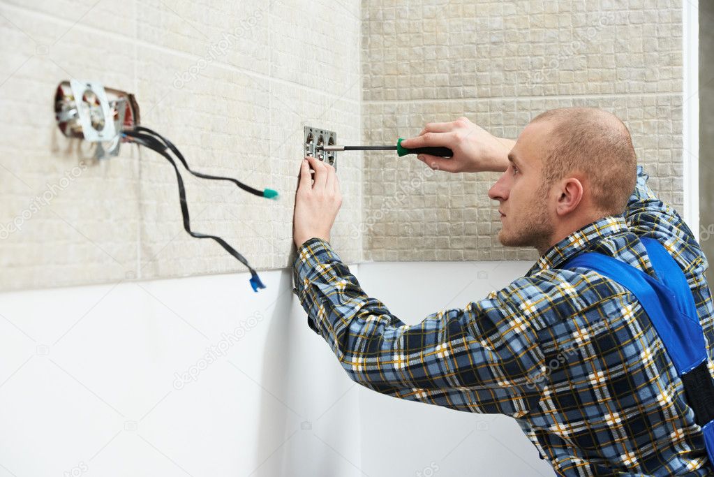 Electrician installing wall outlets