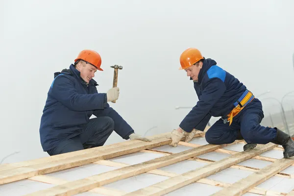 Roofing workers hammer roof boarding — Stock Photo, Image