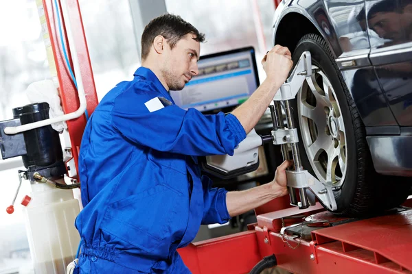 Automechaniker bei Achsvermessungsarbeiten mit Schraubenschlüssel — Stockfoto