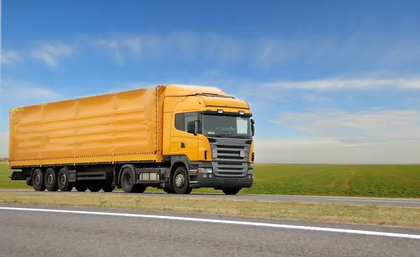 Oranje vrachtwagen met aanhangwagen — Stockfoto