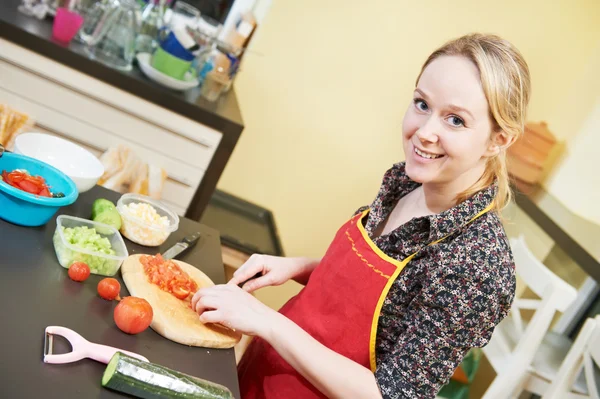 Lachende vrouw in haar keuken koken — Stockfoto