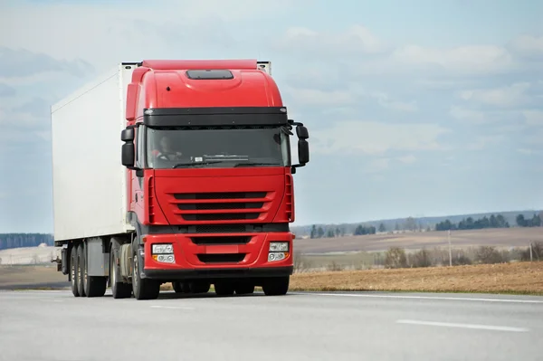 Красный грузовик с белым трейлером над голубым небом — стоковое фото
