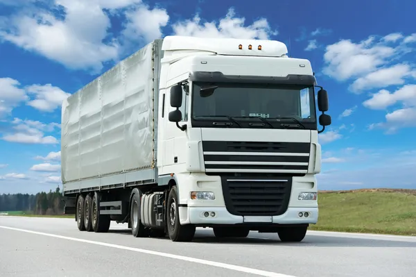 White lorry with grey trailer over blue sky Stock Picture