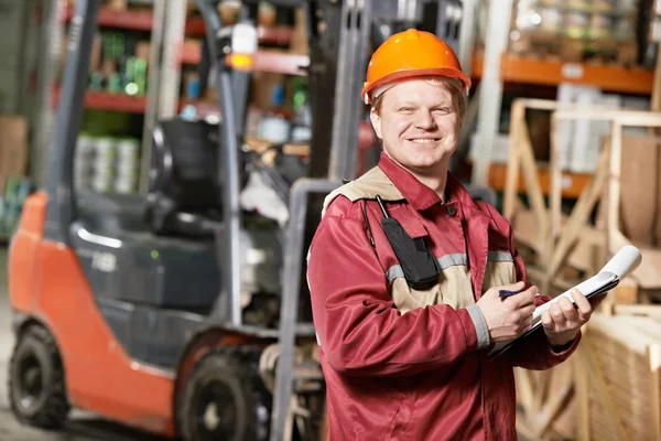 Warehouse worker in front of forklift — Stock Photo, Image