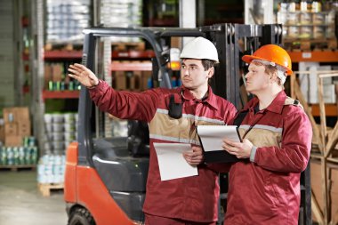 Ambar çalışanlarının önünde forklift