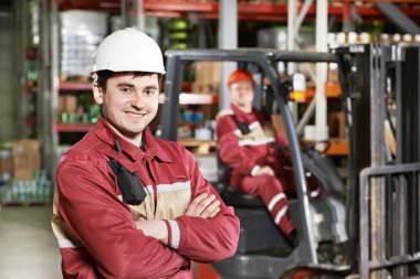 forklift önünde depo işçisi