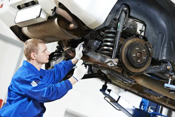 Automonteur op het auto schorsing reparatiewerk — Stockfoto