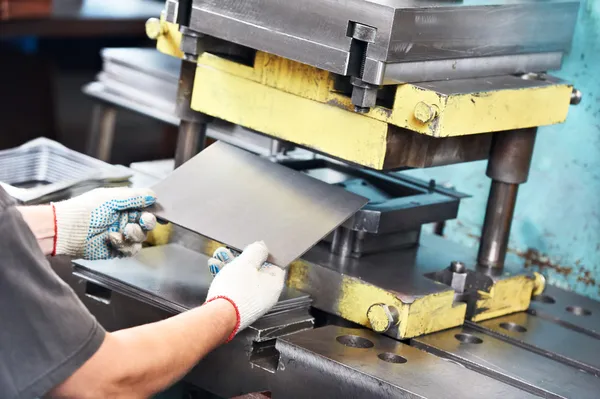 Trabajador operando máquina de prensa de chapa metálica — Foto de Stock