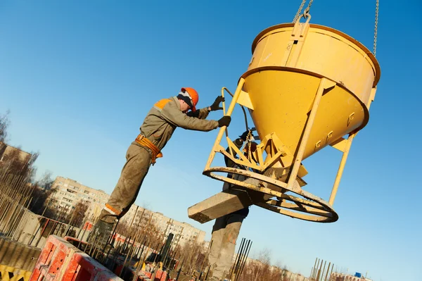 Trabajadores de la construcción vertiendo hormigón con barril — Foto de Stock