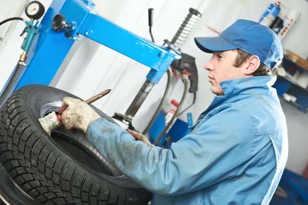 Repairman mechanic lubricating car tyre — Stock Photo, Image