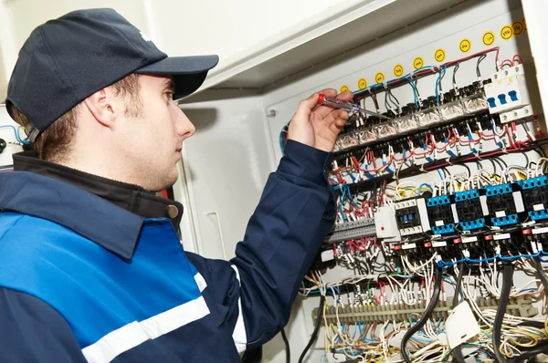 Eletricista em trabalho de ajuste de tensão — Fotografia de Stock