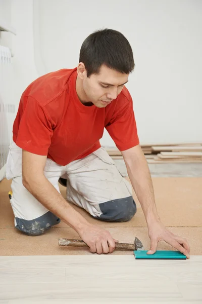 Trabajador carpintero uniéndose al piso del parket — Foto de Stock