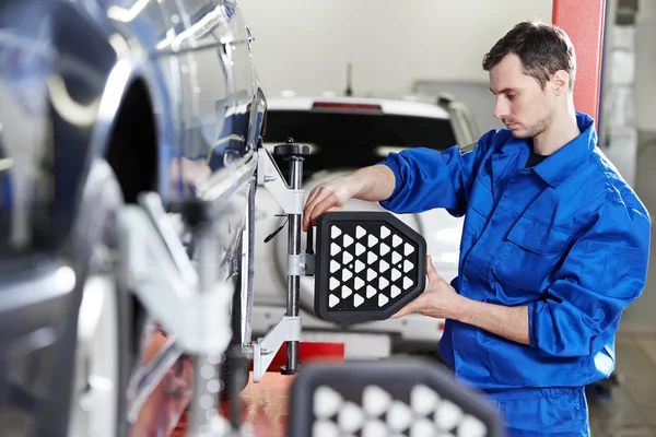 Mecánico automático en el trabajo de alineación de ruedas con sensor — Foto de Stock