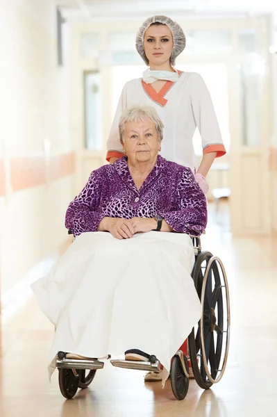 Verpleegster met oudere patiënt in rolstoel — Stockfoto