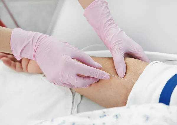 Infoga en nål genom huden för injektion — Stockfoto
