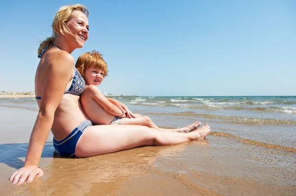 女性と海のビーチで小さな子供 — ストック写真