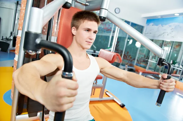 Positive man at chest exercises machine — Stock Photo, Image