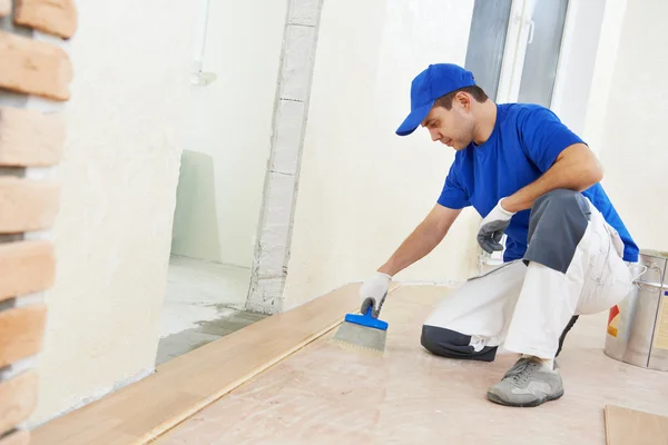 Trabalhador de parquet adicionando cola no chão — Fotografia de Stock