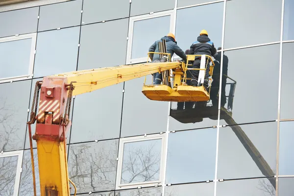 Trabajadores instalando ventana de vidrio en el edificio — Foto de Stock